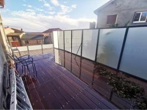 un balcón con una terraza de madera con sillas. en Maison de 4 chambres avec terrasse et wifi a Volvic en Volvic