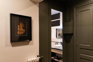 La salle de bains est pourvue de murs verts et d'un miroir. dans l'établissement Magnolia : Superbe deux-pièces quartier du Château, à Pau
