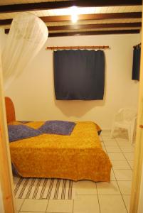 1 dormitorio con 1 cama con cortina en la pared en Maison d'une chambre avec jardin clos et wifi a Grand Bourg, en Grand-Bourg