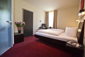 A bed or beds in a room at Hotel Speyer am Technik Museum