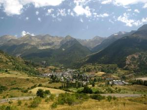une ville dans une vallée avec des montagnes en arrière-plan dans l'établissement Hostal Centro, à Sallent de Gállego
