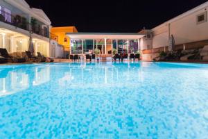 a large blue swimming pool at night at Spa Resort Luxury Apartments in Budva