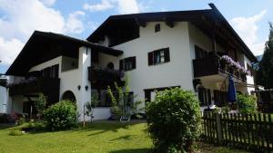 una casa blanca con ventanas negras y una valla en Gästehaus Brigitte, en Garmisch-Partenkirchen