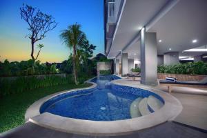 a swimming pool in the middle of a house at Neo Denpasar by ASTON in Denpasar