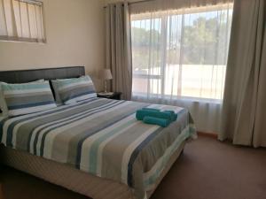 1 dormitorio con 1 cama y ventana grande en Getaway Self-Catering Tyger Valley, en Durbanville