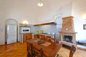 a kitchen with a wooden table and a fireplace at Villa Aristide Amalfi Coast - POOL in Praiano
