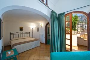 a bedroom with a bed in a room with a window at Villa Aristide Amalfi Coast - POOL in Praiano +8 photos