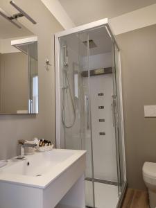 W łazience znajduje się prysznic i biała umywalka. w obiekcie Hotel Cristallo w mieście Conegliano