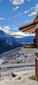 a snow covered roof of a building with a view of mountains at Casa Himalaya, Auli in Joshīmath