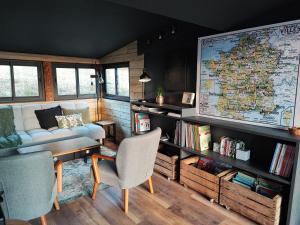 a living room with a couch and a large map at Les Chalets Du Goulet in Le Bleymard