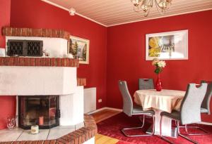a dining room with a table and a fireplace at Ferienhaus Robbers mit 3 Schlafzimmer in Hatten