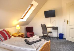 ein Schlafzimmer mit einem Bett, einem Stuhl und einem TV in der Unterkunft Ferienhaus Robbers mit 3 Schlafzimmer in Hatten