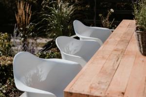 een houten tafel met vier witte stoelen eromheen bij Ferienhaus Pier 1 in Ahlbeck