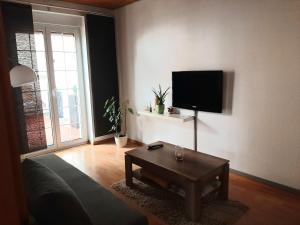 a living room with a couch and a table and a tv at Ferienwohnung in Flörsheim