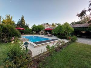 a swimming pool in a yard next to a house at Le clos des Noaillettes in Puybarban