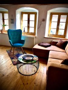 ein Wohnzimmer mit einem Sofa und einem blauen Stuhl in der Unterkunft Apartments Altstadthaus Görlitz in Görlitz