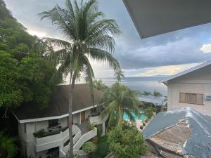 een uitzicht op een huis met een palmboom bij Pier Uno Dive Resort powered by Cocotel in Mabini