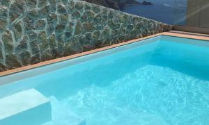 a large blue swimming pool with a stone wall at Villa Aristide Amalfi Coast - POOL in Praiano