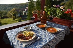 a table with a plate of food and glasses of wine at Siklód. Csaba vendégház (5 fő) in Şiclod