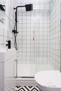 y baño con ducha, aseo y lavamanos. en Stylish 5 Bedroom 5 Bathroom House (Sleeps 10) with Garden, Smart TV and Free Parking by Yoko Property en Coventry