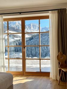 a bedroom with a large window with a mountain view at Cosy Winter - Luxury Chalet at the foot of the Dolomites in La Villa