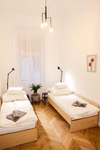 Habitación con 2 camas, paredes blancas y suelo de madera. en Central 3 bedroom apartment for 6 guests - AC, Wi-Fi, Self check in-out, Professional hosts, en Budapest