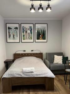 a bedroom with a bed and three pictures on the wall at Kameralne Studio w centrum Częstochowy in Częstochowa