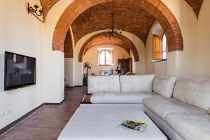 a living room with a couch and a tv at Villa Eleonora in Lucignano