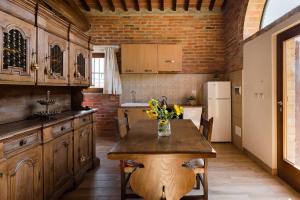 a kitchen with a table with a vase of flowers on it at Villa Eleonora in Lucignano