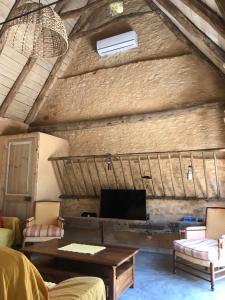 圣西普里安Gîte du Meynet的配有电视、桌椅的客厅