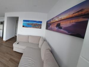 un soggiorno con un divano bianco e 2 dipinti di Casa Cetáceo a Playa Quemada