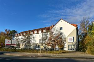 un grand bâtiment blanc sur le côté d'une rue dans l'établissement HESSE HOTEL Celle, à Celle