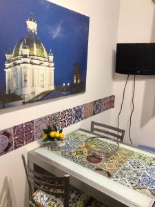 een eettafel met mozaïektegels aan de muur bij La Colombaia in Trapani