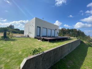 a small house with a concrete wall at ゴールデンマイルヴィラ in Amami