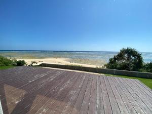 a wooden deck with a view of the beach at ゴールデンマイルヴィラ in Amami