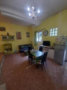 a living room with a table and a refrigerator at Le bananier in Bouillante