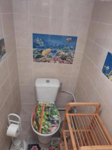 a bathroom with a toilet with a fish tank on it at Le bananier in Bouillante