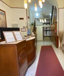 una hall con bancone e tappeto rosso di Hotel Eliseo Napoli a Napoli