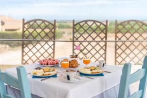 un tavolo bianco con cibo e bevande di Agriturismo S'Incant'e Sinis a San Salvatore