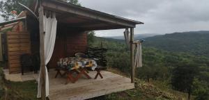 uma mesa sentada num convés de uma cabina em Petit chalet de montagne em Saint-Nectaire