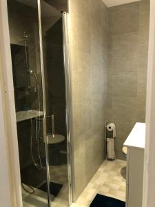 una doccia con porta in vetro in bagno di AU MIMOSA - Chambre d'hôte Le Laurier a Passa