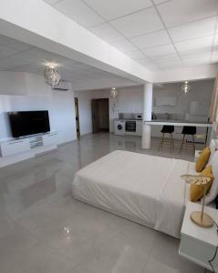 a large white room with a bed and a flat screen tv at Hello Guyane(3), Suite Prestige Premium, 5 étoiles in Cayenne