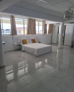 a white bedroom with a bed in a room with windows at Hello Guyane(3), Suite Prestige Premium, 5 étoiles in Cayenne +13 photos
