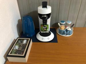 a coffee maker sitting on a wooden shelf with a picture at AU MIMOSA - Chambre d'hôte Le Laurier in Passa