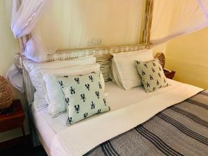 Un dormitorio con una cama con almohadas. en SUNSET BEACH HAVEN, Entire Villa, Beachfront, Pool, Private en Galle