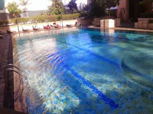 a large swimming pool with blue water at 2 bedroom modern city center apartment in Bangkok