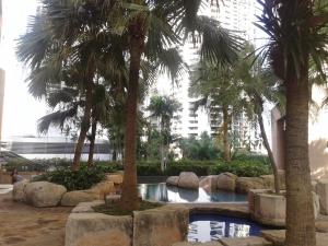 a swimming pool with palm trees in a building at 2 bedroom modern city center apartment in Bangkok