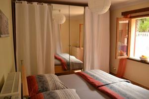 une chambre avec deux lits et une fenêtre et un miroir dans l'établissement CASA LA SIESTA- Ruhiges Ferienhaus in Cala Ratjada, 300 m vom Strand Son Moll entfernt, à Cala Ratjada