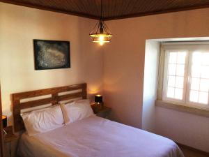 ein Schlafzimmer mit einem weißen Bett und einem Fenster in der Unterkunft Art`Rio - Casa no Rio em Dornes in Dornes