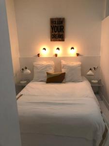 een slaapkamer met een wit bed met 2 verlichting bij Sainte Apartments in Marseille